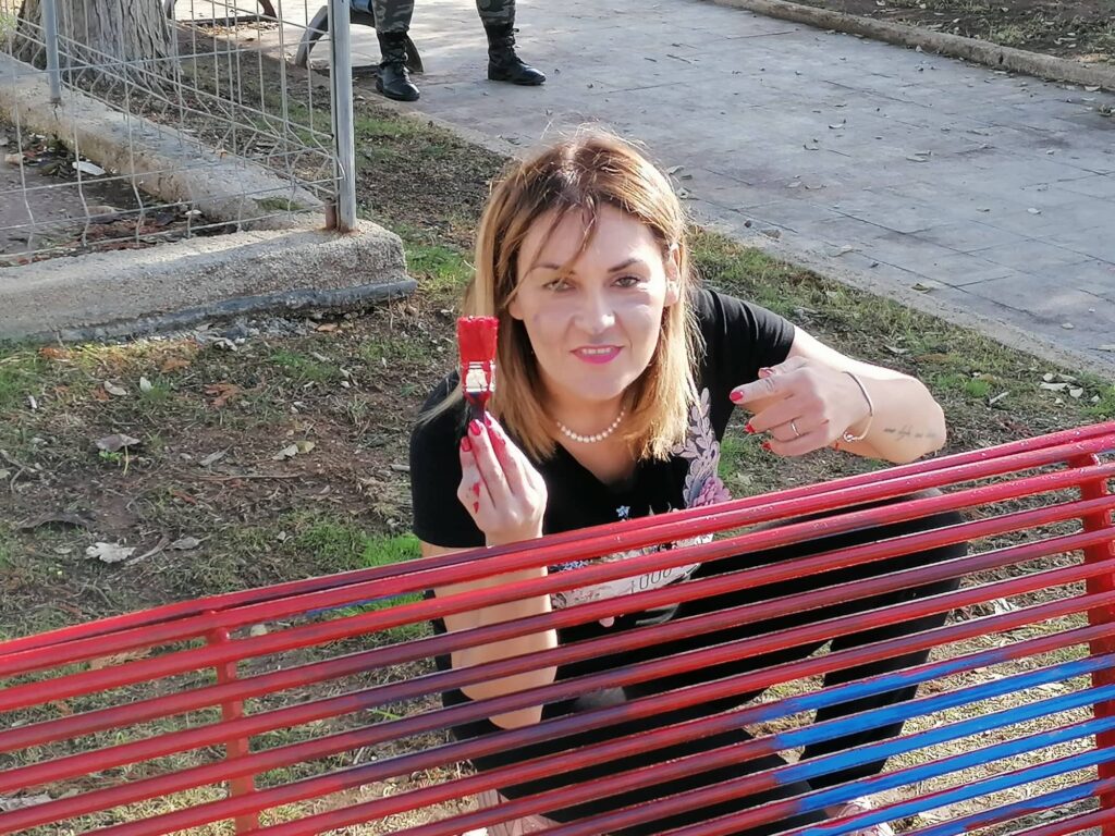 Arianna Greco al lavoro per abbellire la prima panchina rossa a Porto Cesareo.